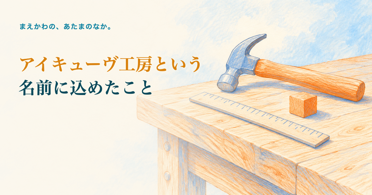 アイキューヴ工房という名前に込めたこと。木の作業台の上の金づち、ものさし、オレンジ色の小さな立方体の色鉛筆調イラスト