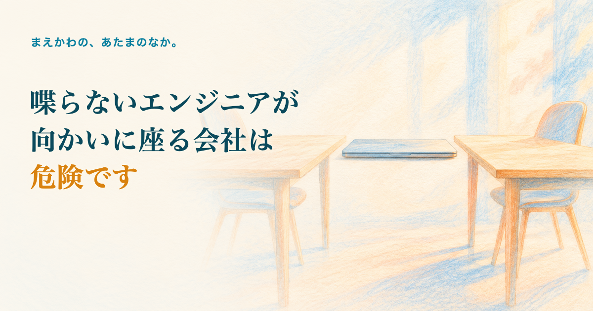 喋らないエンジニアが向かいに座る会社は危険です。向かい合う二つの机と、真ん中の閉じたノートパソコン、静けさの色鉛筆調イラスト
